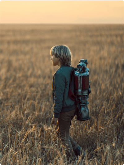 Boy wearing jet pack in a field