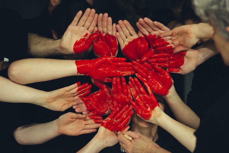 A collection of hands held up with a heart painted on them. Image credit: Tim Marshall.